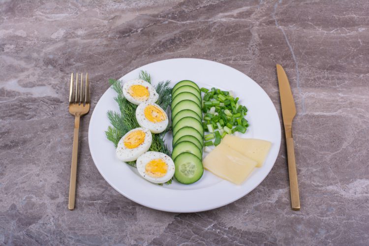 boiled eggs with sliced cucumbers herbs white plate scaled 1
