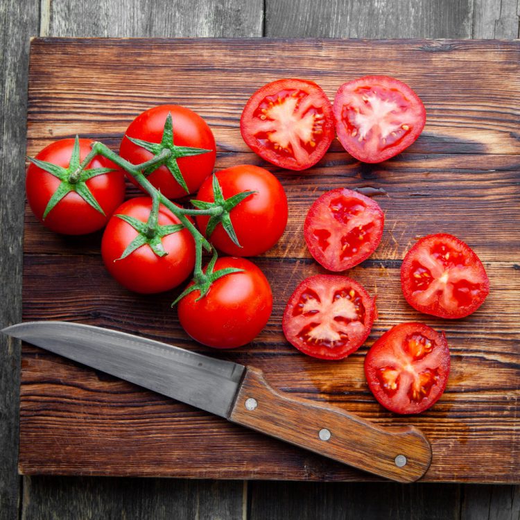 top view tomatoes slices wooden cutting board with knife dark wooden background 1