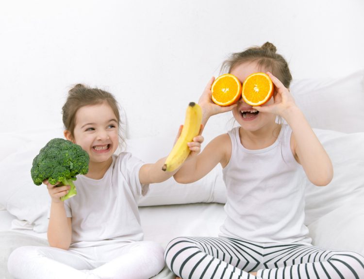 happy two cute children play with fruits vegetables light background healthy food children