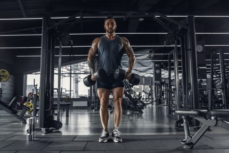 young muscular caucasian athlete practicing gym with weights